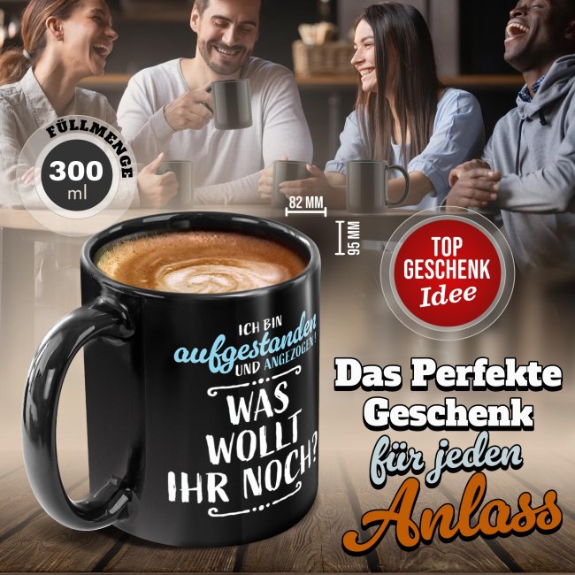 Schwarze Tasse mit Spruch - Aufgestanden und angezogen - Was wollt ihr noch?